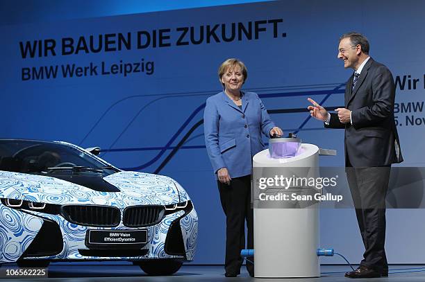 German Chancellor Angela Merkel and BMW Chairman Norbert Reithofer lower a container with messages into a capsule while speaking at the BMW auto...