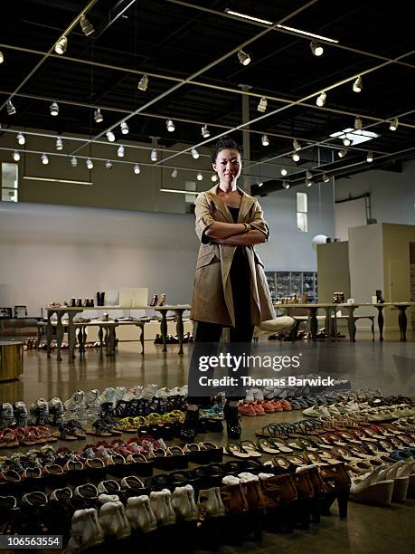 designer standing in showroom surrounded by shoes - fashion showroom fotografías e imágenes de stock