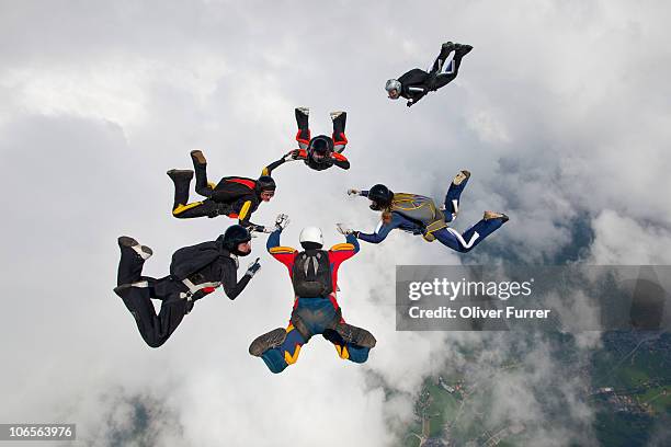 divers try to work together by holding hands. - skydiving formation stock pictures, royalty-free photos & images