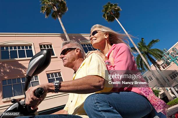 senior caucasian couple on motor scooter. - boca raton stockfoto's en -beelden