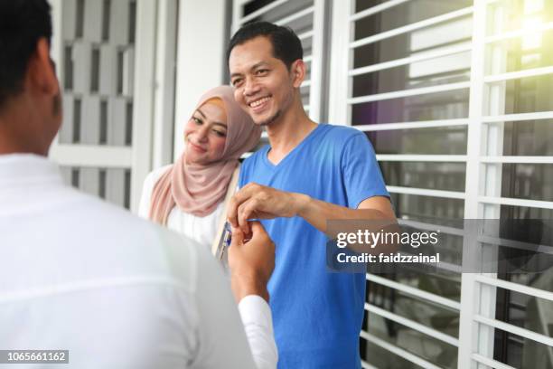 malay muslim couples receiving house keys to new home - malay couple stock pictures, royalty-free photos & images