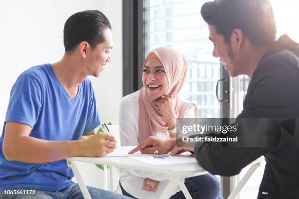 erwachsenen malaiischen muslime signieren von dokumenten für haus kauf / vermietung - malay culture stock-fotos und bilder