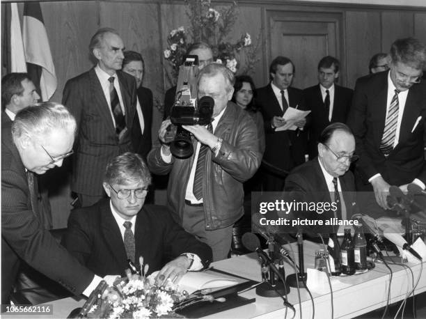 German Foreign Minister Hans-Dietrich Genscher and Czechoslovakian Foreign Minister Jiri Dienstbier sign an agreement consisting of results from...