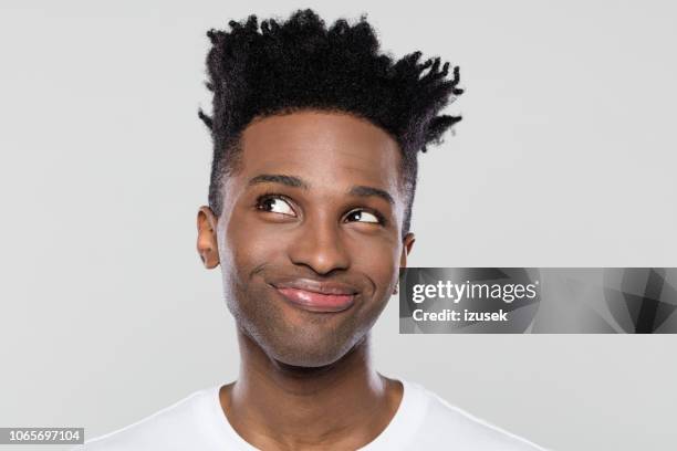 young man looking away with a smile on face - sorriso discreto imagens e fotografias de stock