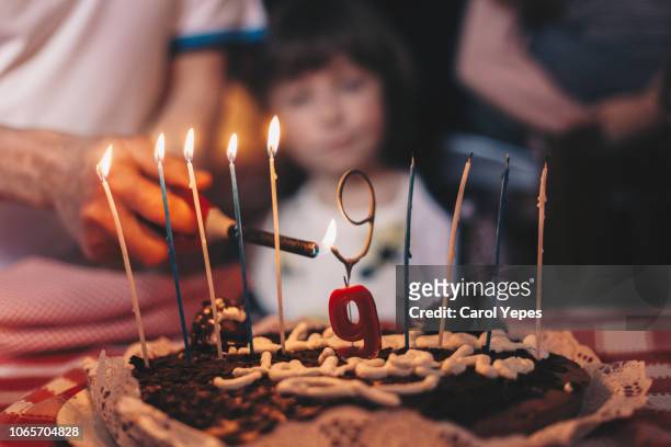hand lighting candles in a birthday cake - number 9 stock pictures, royalty-free photos & images