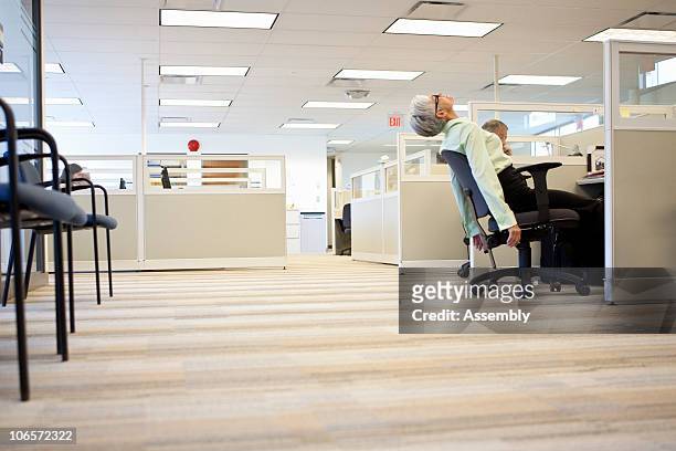 mature business woman leans back in chair  - boring man stock-fotos und bilder