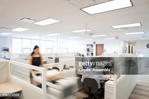 woman pushing mail cart in office