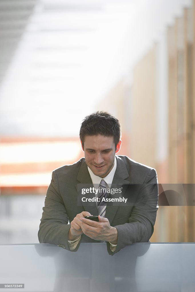 Man in suit using wireless device in office space