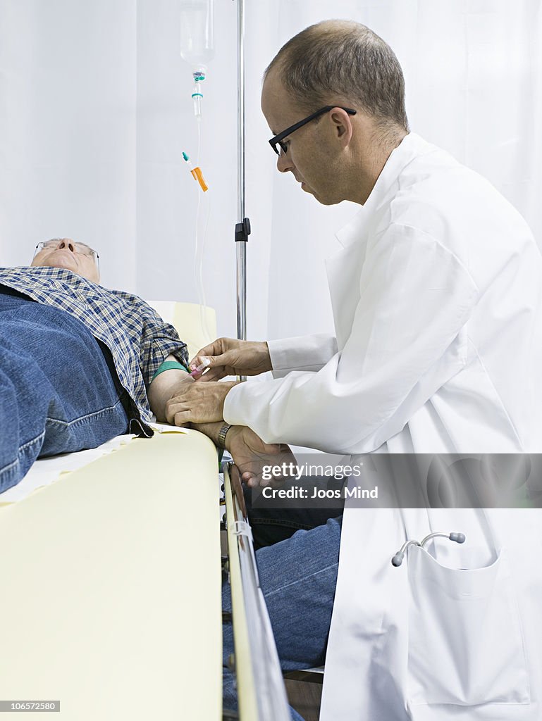 Doctor placing IV drip needle