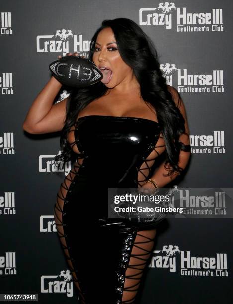 Adult film actress Kiara Mia licks a football as she arrives at the Crazy Horse 3 Gentlemen's Club to host a party on November 10, 2018 in Las Vegas,...