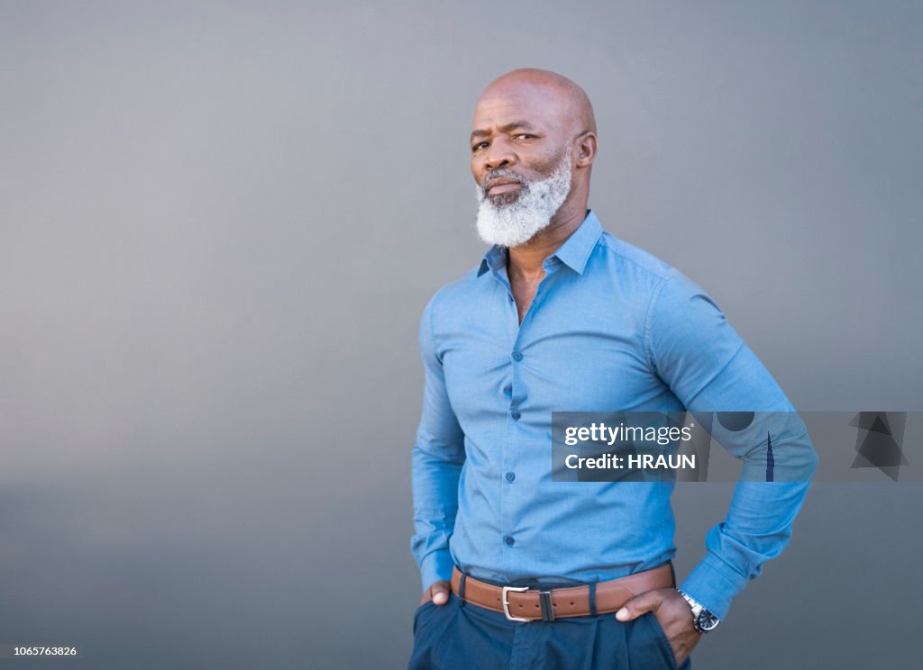Retrato de hombre afroamericano confiado contra pared gris