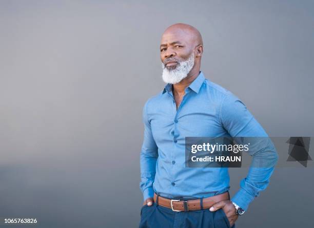 ritratto di uomo afroamericano fiducioso contro muro grigio - man standing against grey background foto e immagini stock