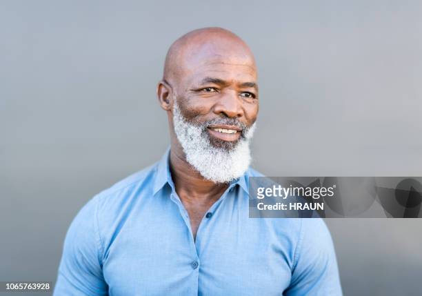 afrikanische amerikanische mann wegsehen mit händen in den taschen - african american male style stock-fotos und bilder
