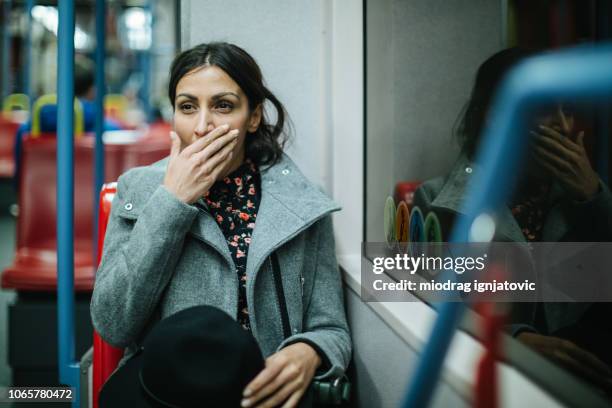 müde frau in öffentlichen verkehrsmitteln - müdigkeit winter stock-fotos und bilder