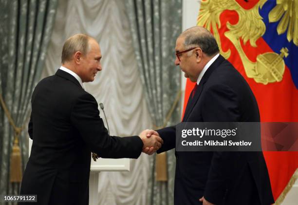 Russian President Vladimir Putin greets billionaire and businessman Alisher Usmanov during the State Awards Ceremony at the Kremln in Moscow,...