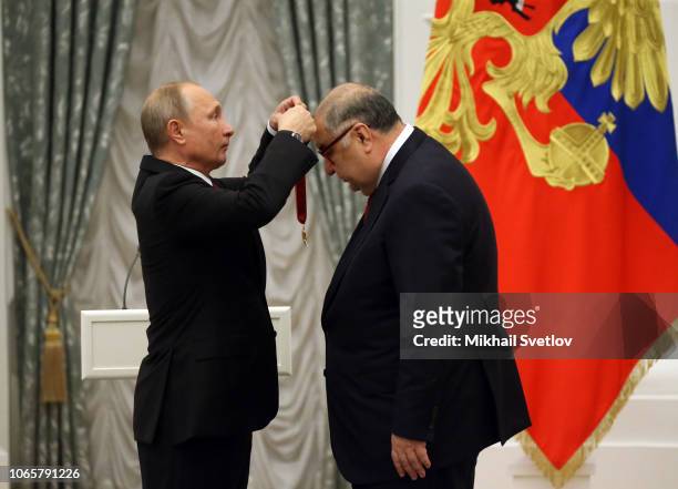 Russian President Vladimir Putin greets billionaire and businessman Alisher Usmanov during the State Awards Ceremony at the Kremln in Moscow,...