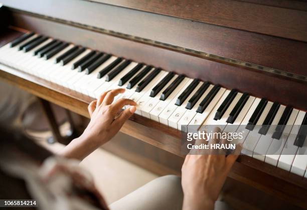 bijgesneden vrouw thuis speelt piano - piano stockfoto's en -beelden
