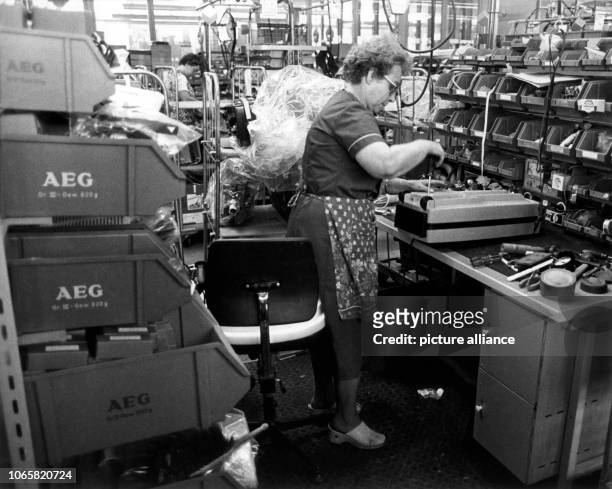 Employees repair small devices in the works for domestic appliances of AEG in Nuremberg on the 31st of August in 1982. | usage worldwide