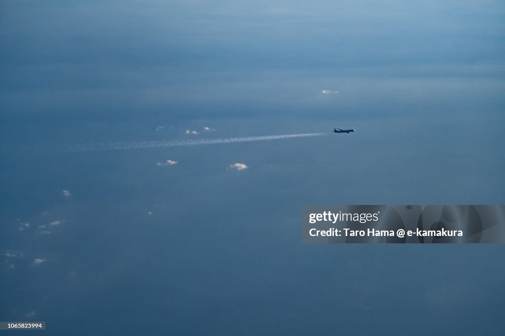 The flying airplane on Pacific Ocean in Japan daytime aerial view from airplane