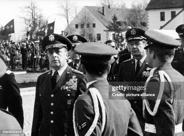 Generals Lyman L. Lemnitzer and David A. Burchinal walking past an honor guard during a military parade in honor of the taking over of the new...