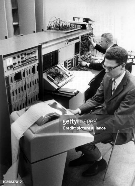 Two employees activating a new hybrid calculation system, consisting of the digital computer CAE 90-40, the AEG tele funk analog computer RA 770, and...
