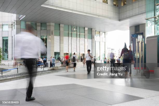 blurred motion of businesspeople walking - singapore people stock-fotos und bilder