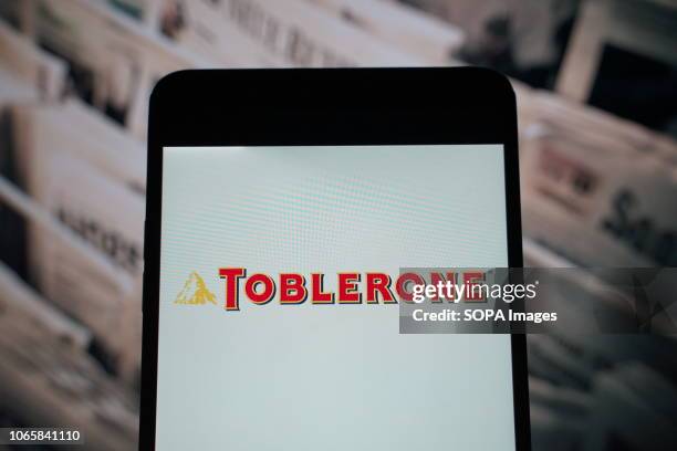 In this photo illustration, the logo of Toblerone is seen displayed on a smartphone.