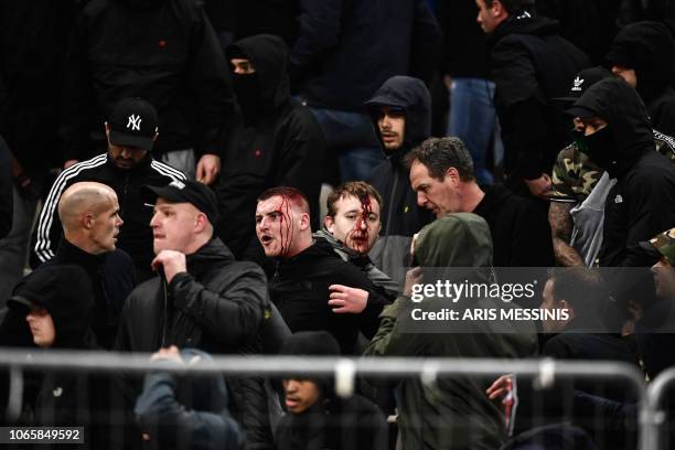 Bleeding Ajax fans react after clashes with Greek riot police prior to the start of the UEFA Champions League football match between AEK Athens FC...