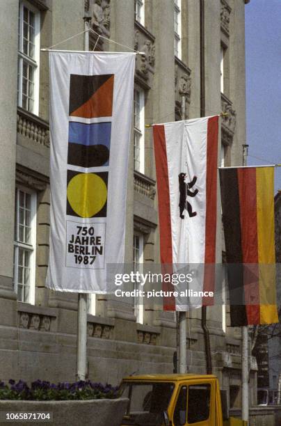 An official flag for the 750th city anniversary , a Berlin city flag with the "bear" from Berlin and a German flag hang in front of Schoeneberger...