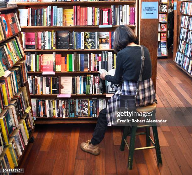 Customer peruses a book at City Lights Bookstore in San Francisco, California. The landmark independent bookstore was founded in 1953 by poet...