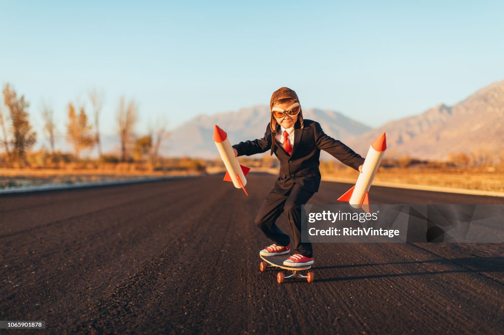 Business Boy Holding Rockets Standing on Skateboard