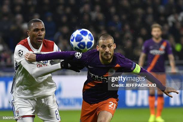 Lyon's Brazilian defender Marcelo vies with Manchester City's Spanish midfielder David Silva as he eyes the ball during the UEFA Champions League...