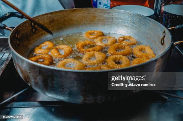 donuts frying in a pan - freidora fotografías e imágenes de stock