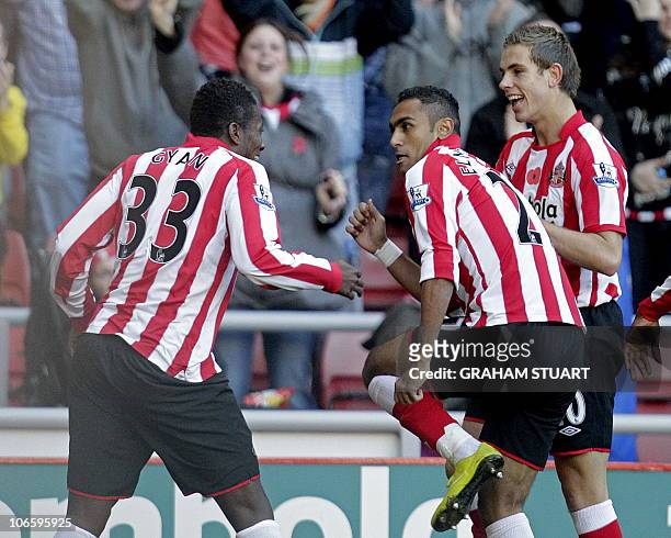 Sunderland's Ghanaian striker Asamoah Gyan celebrates scoring the opening goal with Egyptian midfielder Ahmed Elmohamady and English midfielder...