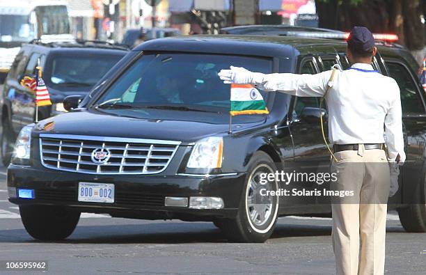 An Indian traffic policeman displays the direction of travel to the special limouzine transporting US President Barack Obama during his visit to...