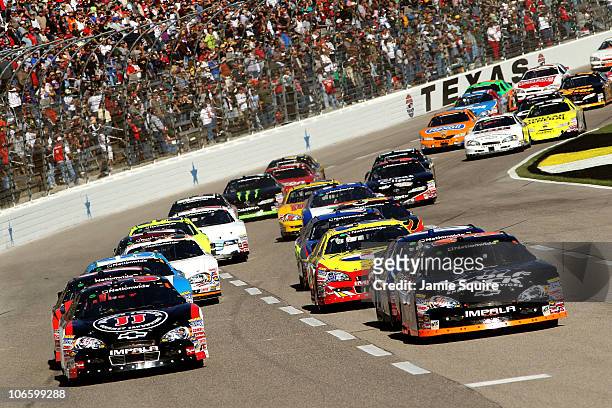 James Buescher, driver of the Wolfpack Energy Services Chevrolet, and Kevin Harvick, driver of the Jimmy John's Chevrolet, lead the field during the...