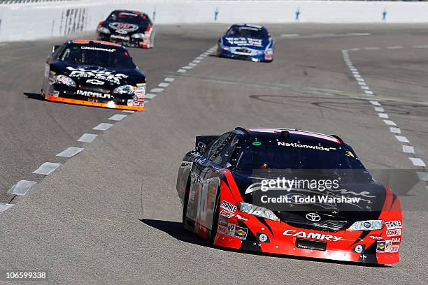 Kyle Busch, driver of the Z-Line Designs Toyota, leads James Buescher, driver of the Wolfpack Energy Services Chevrolet, Kevin Harvick, driver of the...