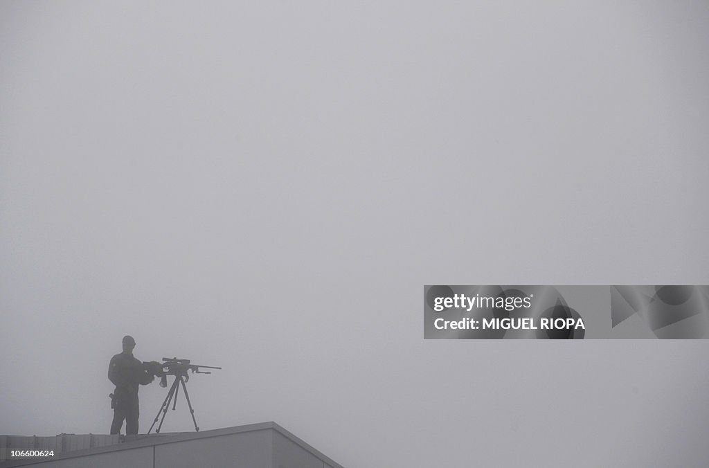 An armed Civil Guard stands on a roof of