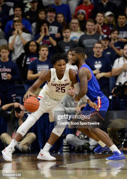 UConn Huskies forward Josh Carlton dribbles in to post while UMass Lowell River Hawks guard Darius Henderson defends as the UMass Lowell River Hawks...