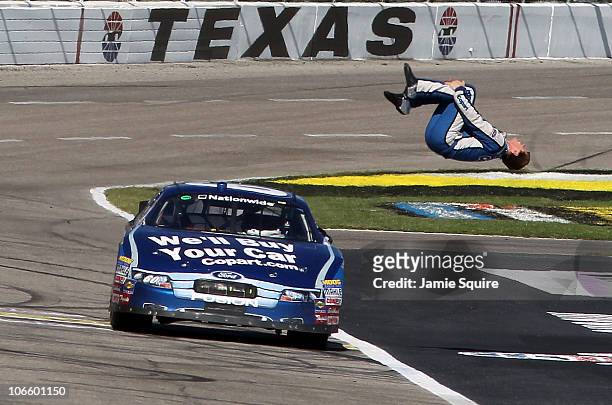 Carl Edwards, driver of the Copart.com Ford, does a back flip as he celebrates after winning the NASCAR Nationwide Series O'Reilly Auto Parts...