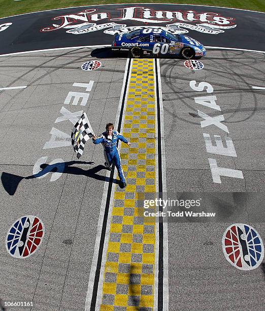 Carl Edwards, driver of the Copart.com Ford, celebrates with the checkered flag after winning the NASCAR Nationwide Series O'Reilly Auto Parts...