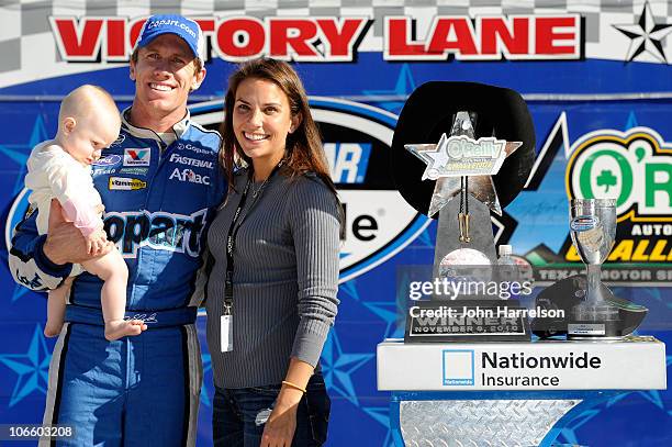 Carl Edwards , driver of the Copart.com Ford, holds his daughter Anne with his wife Kate in Victory Lane after winning the NASCAR Nationwide Series...