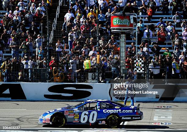 Carl Edwards, driver of the Copart.com Ford, catches the checkered flag after winning the NASCAR Nationwide Series O'Reilly Auto Parts Challenge at...