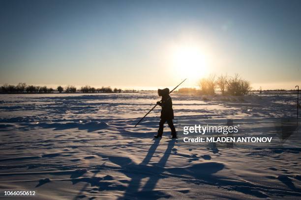 Villagers harvest ice from a local lake near the settlement of Oy, some 70 km south of Yakutsk, with the air temperature at about minus 41 degrees...