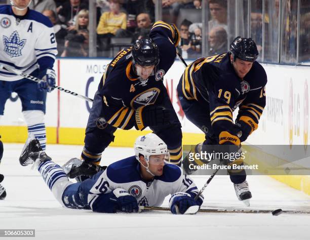 Clarke MacArthur of the Toronto Maple Leafs struggles to control the puck against Steve Montador and Tim Connolly of the Buffalo Sabres at the Air...