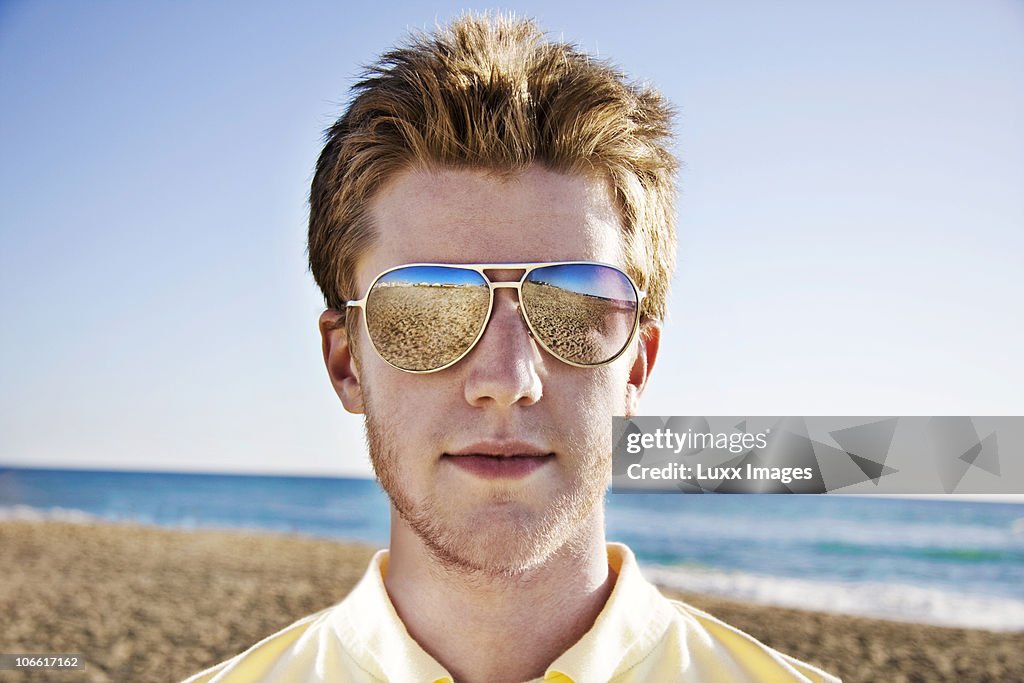 Portrait of young man with sunglasses at beach