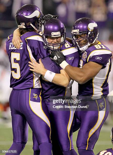 Kicker Ryan Longwell, holder Chris Kluwe, and receiver Visanthe Shiancoe of the Minnesota Vikings celebrate their game winning field goal in overtime...