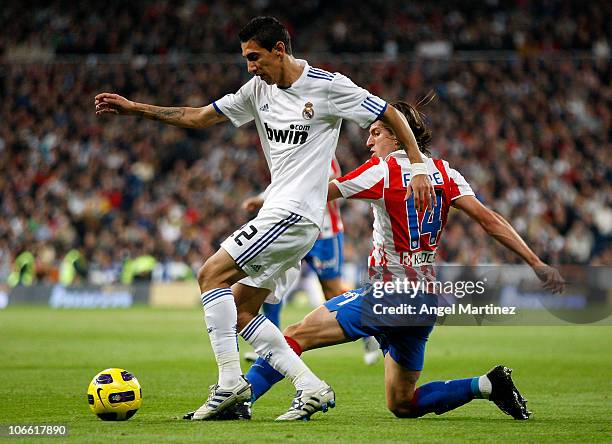 Angel di Maria of Real Madrid is tackled by Filipe Luis Karsmirski of Atletico Madrid during the La Liga match between Real Madrid and Atletico...