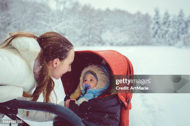 mother and son in winter park - carriage stock pictures, royalty-free photos & images