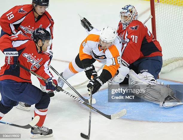 The Philadelphia Flyers' Mike Richards flies through the crease while attempting to get a shot off against Washington Capitals goalie Braden Holtby ,...